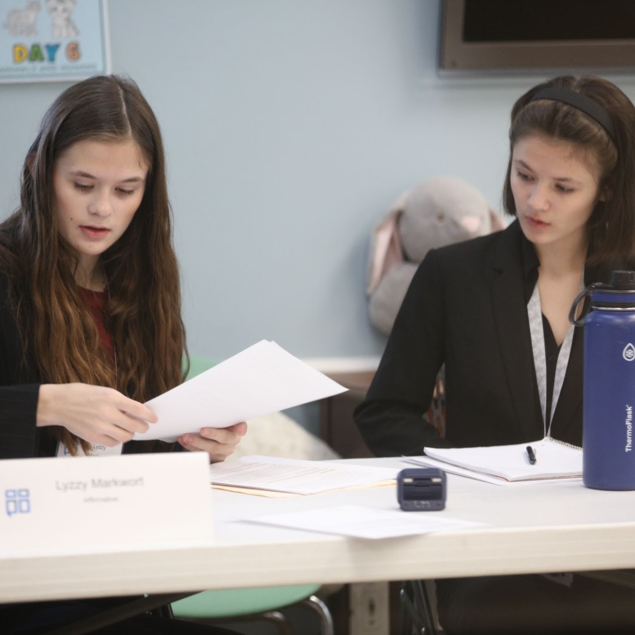 Students reviewing notes at the debate table